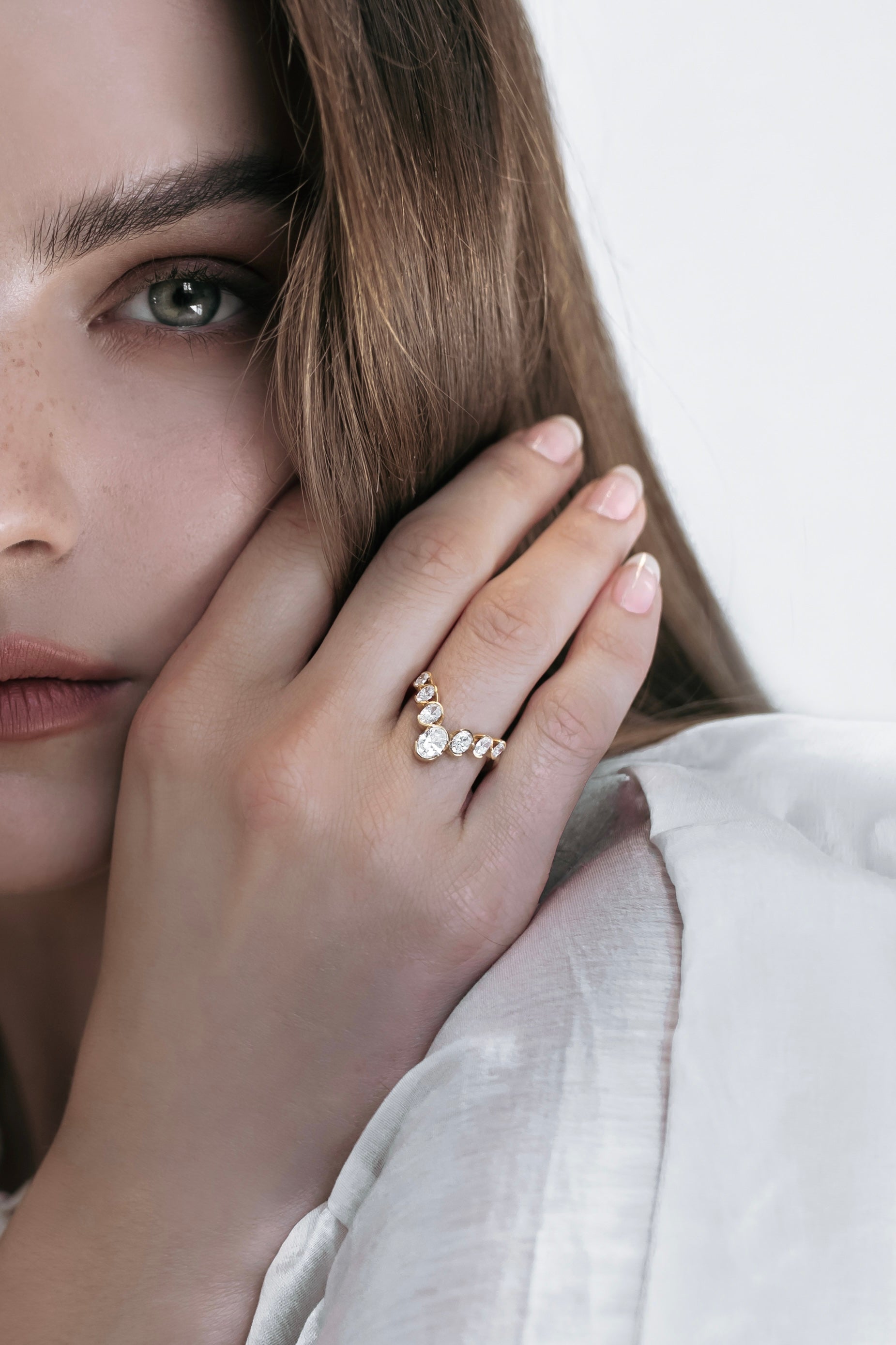 Close-up of the J’ador V-Bloom ring by Presiada, delicately worn by a model. The 18K gold V-shaped design is enhanced with oval diamonds, embodying floral elegance and romantic charm. Perfect for those who value femininity and timeless beauty, available in natural or lab-grown diamonds.