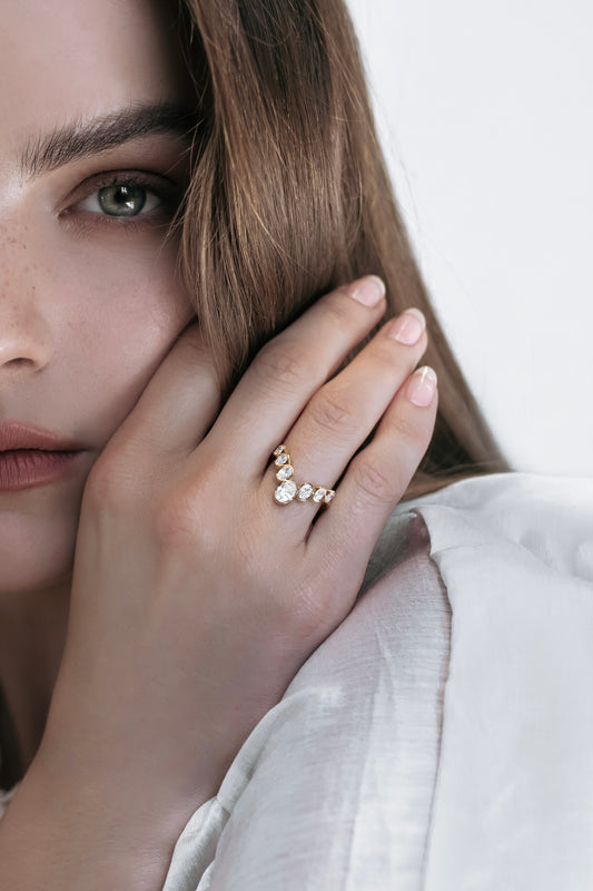 Close-up of the J’ador V-Bloom ring by Presiada, delicately worn by a model. The 18K gold V-shaped design is enhanced with oval diamonds, embodying floral elegance and romantic charm. Perfect for those who value femininity and timeless beauty, available in natural or lab-grown diamonds.
