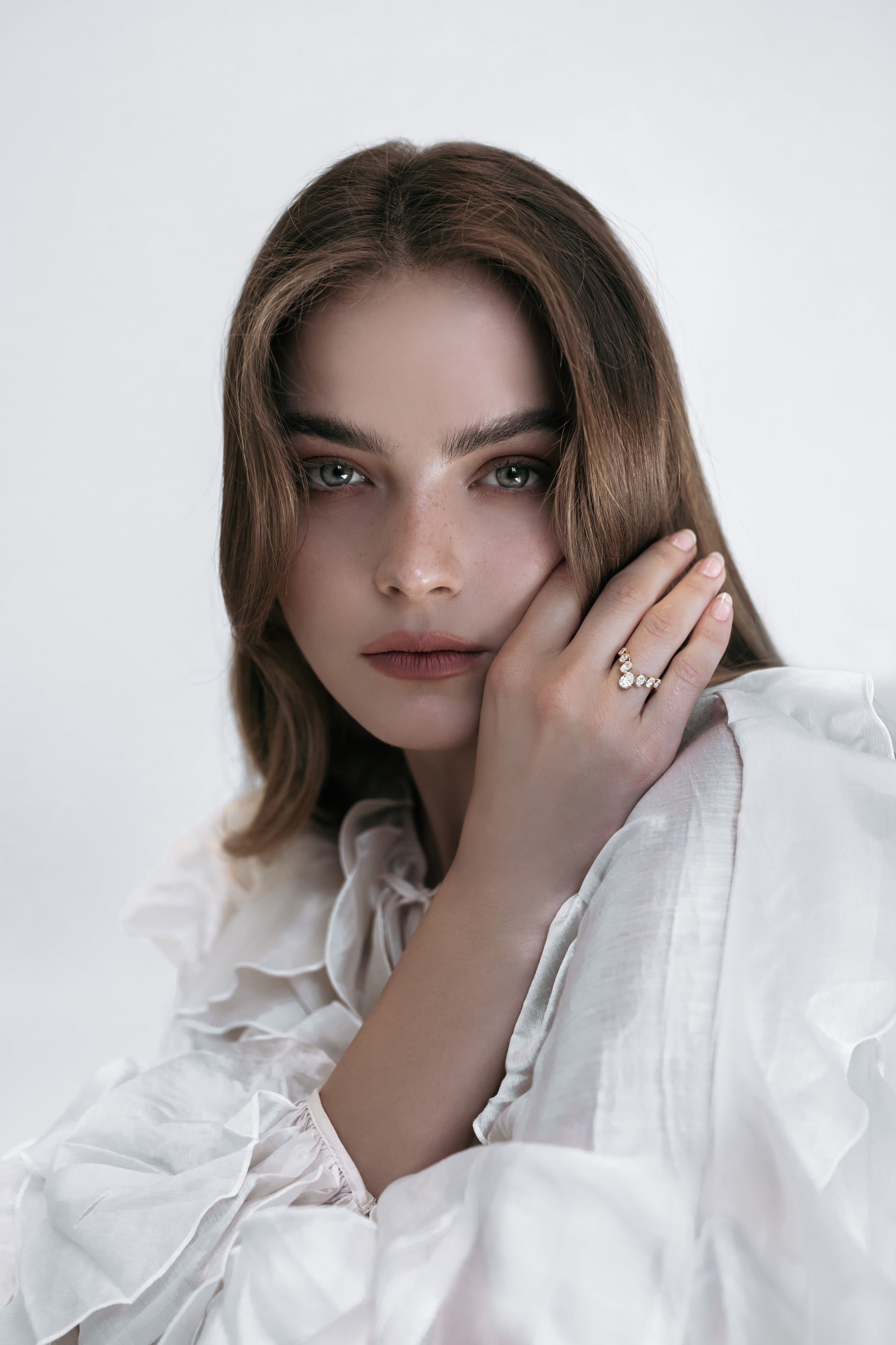 Close-up of a model wearing the J’ador V-Bloom ring by Presiada, crafted in 18K gold with a delicate V shape adorned with oval diamonds. This romantic and graceful piece symbolizes floral elegance, perfect for those who appreciate timeless beauty. Available in natural or lab-grown diamonds.