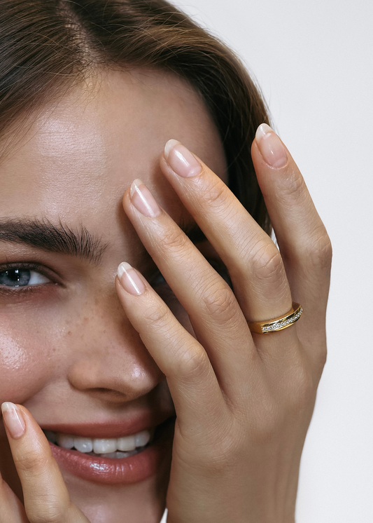 Close-up of a smiling model wearing the L’Arc ring by Presiada. Crafted in 18K gold, the bold arc design is enhanced with pavé-set diamonds (approximately 0.10 ct), combining sophistication and modern elegance. Perfect for everyday wear, the ring is available with natural or lab-grown diamonds as part of the Sensation Collection.