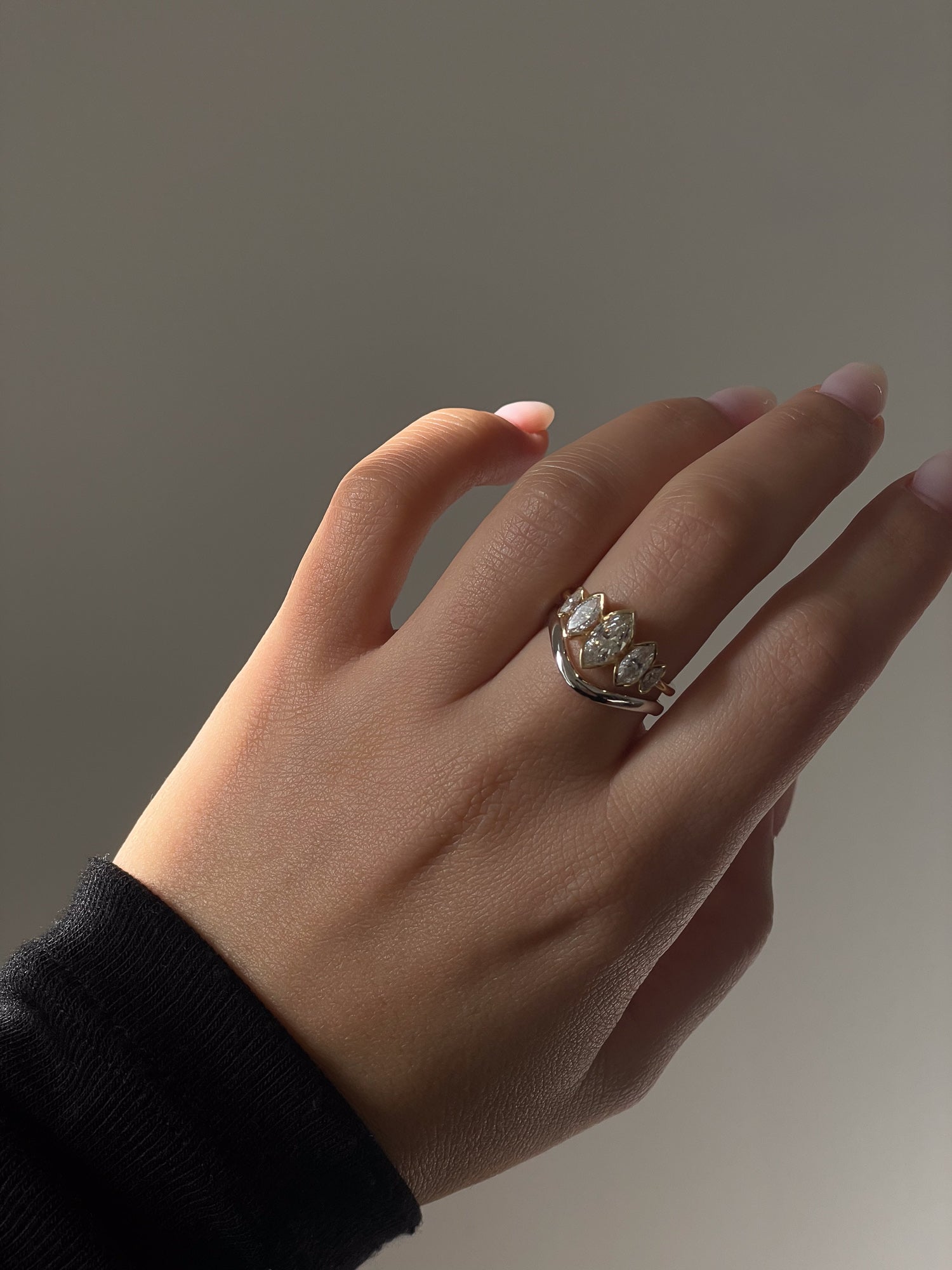 A model showcasing the Wave Ring with La Divine Lab or Natural Diamonds Engagement Ring by Presiada, a sculptural twisted band crafted in 14K or 18K gold. This elegant yet modern wedding band perfectly complements engagement rings or stands alone as a timeless statement.