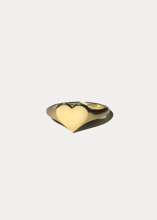 Close-up packshot of the Fine Heart Signet Ring by Presiada Jewelry. A bold yet refined heart-shaped ring, crafted in 14K or 18K solid gold, designed to make an elegant statement. Available in yellow or white gold.