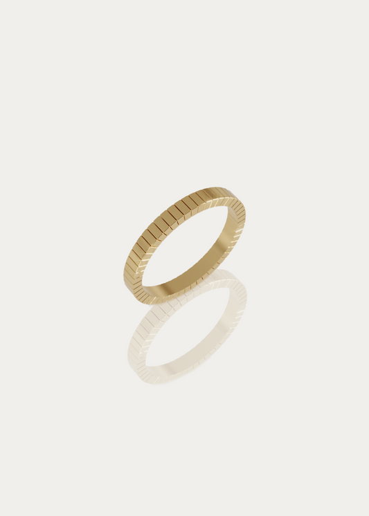 High-quality packshot of the Line Ring by Presiada Jewelry. This sleek 14K or 18K gold band features engraved straight lines for a sophisticated, modern touch. Available in yellow or white gold.