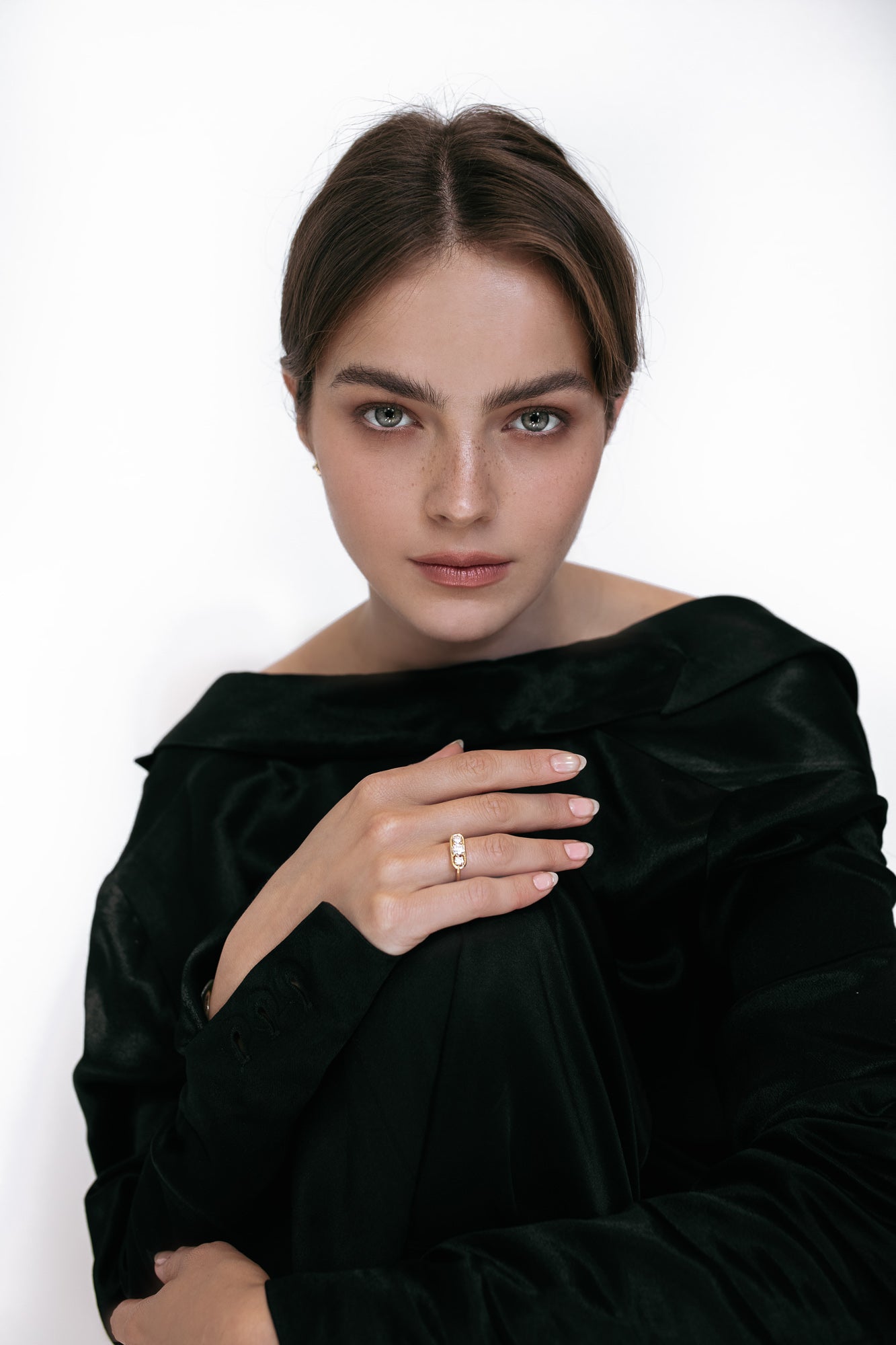 Close-up of a model wearing the Élevé ring by Presiada, crafted in 18K gold. The Élevé ring features a stunning floating frame diamond design with a central diamond and two side accents, offering modern sophistication and timeless elegance. Part of the Sensation Collection, it is available in natural or lab-grown diamonds to suit your preferences.