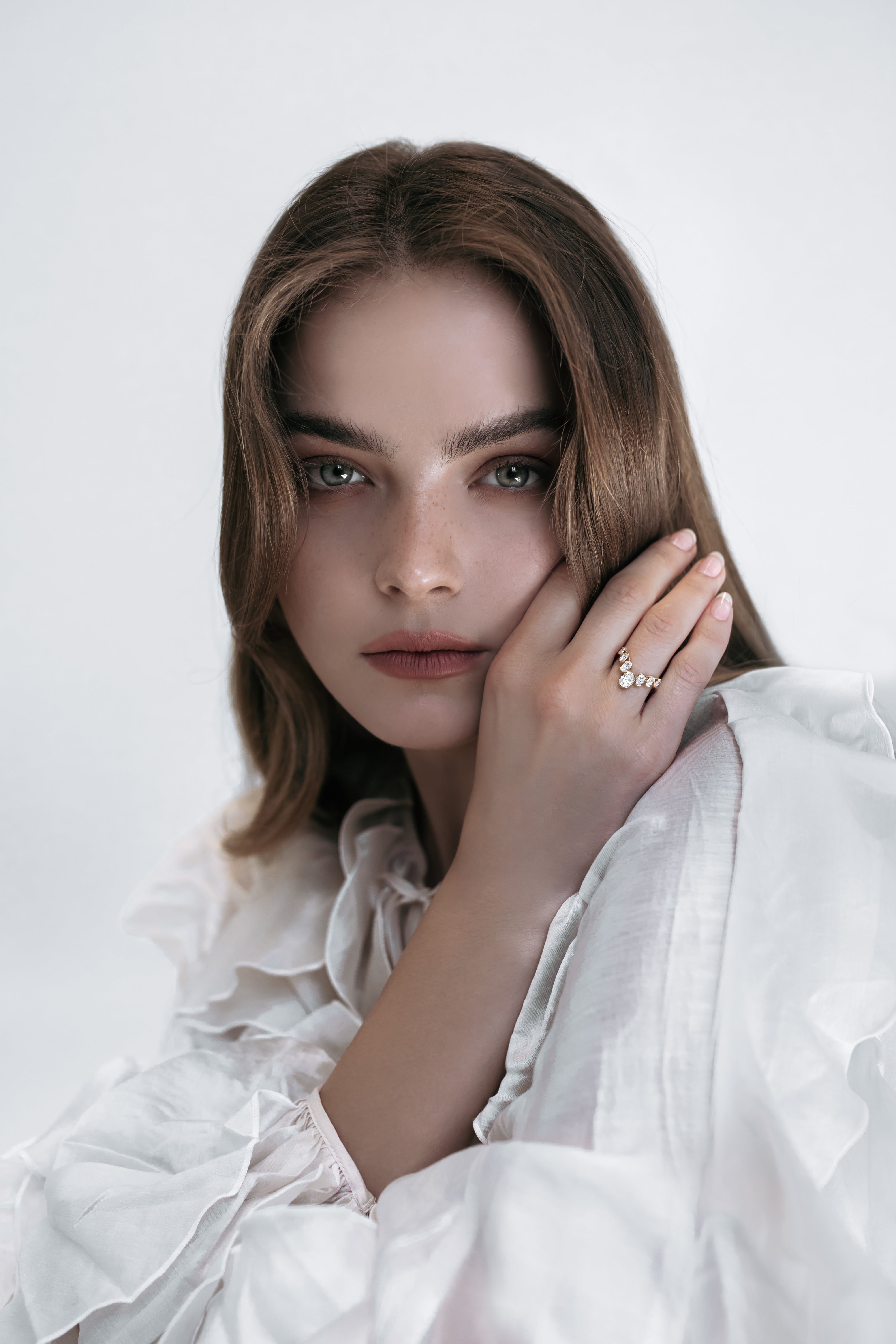 Close-up of a model wearing the J’ador V-Bloom ring by Presiada, crafted in 18K gold with a delicate V shape adorned with oval diamonds. This romantic and graceful piece symbolizes floral elegance, perfect for those who appreciate timeless beauty. Available in natural or lab-grown diamonds.