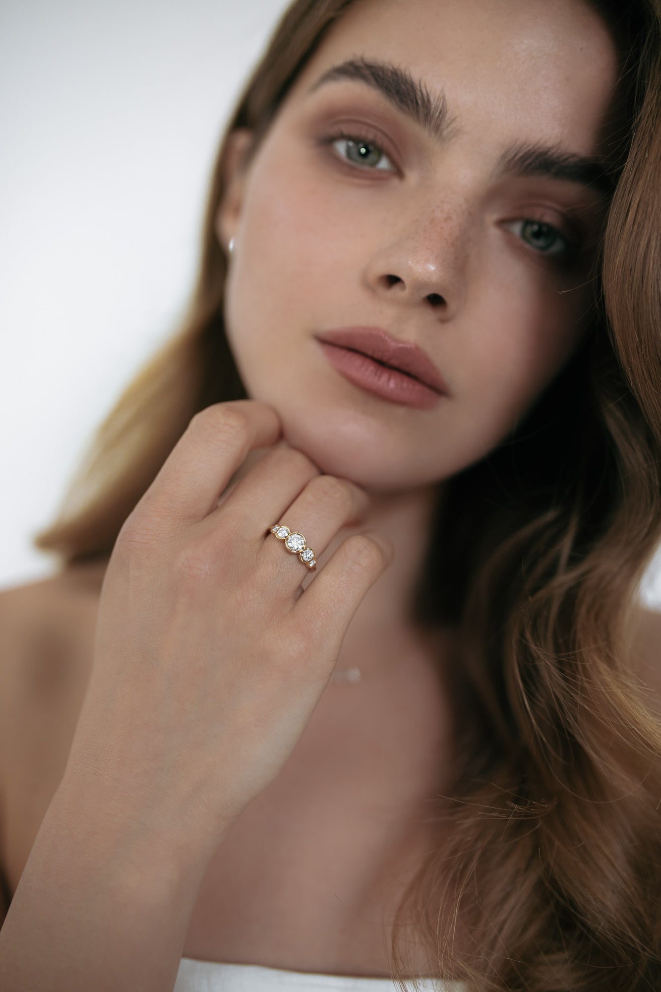 Close-up of a model wearing the La Belle engagement ring by Presiada, crafted in 18K gold. The ring features five round diamonds set in perfect harmony, blending classic elegance with a modern twist. A unique, made-to-order piece, perfect for those seeking a timeless and personalized engagement ring.