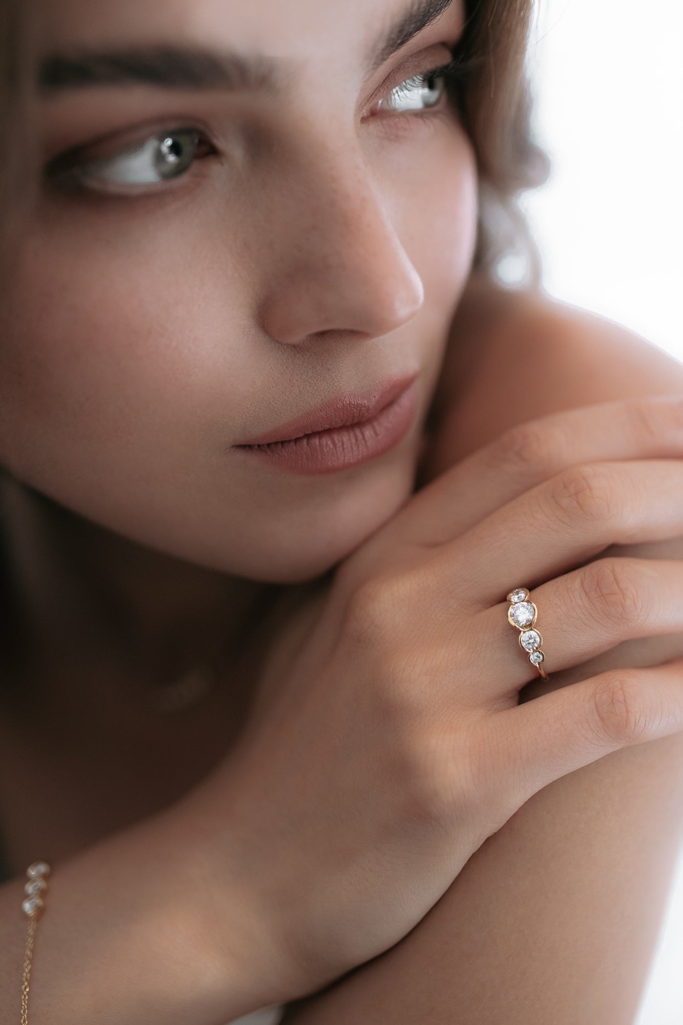 Close-up of a model wearing the La Belle engagement ring by Presiada, crafted in 18K gold. The ring features five round diamonds set in perfect harmony, blending classic elegance with a modern twist. A unique, made-to-order piece, perfect for those seeking a timeless and personalized engagement ring.