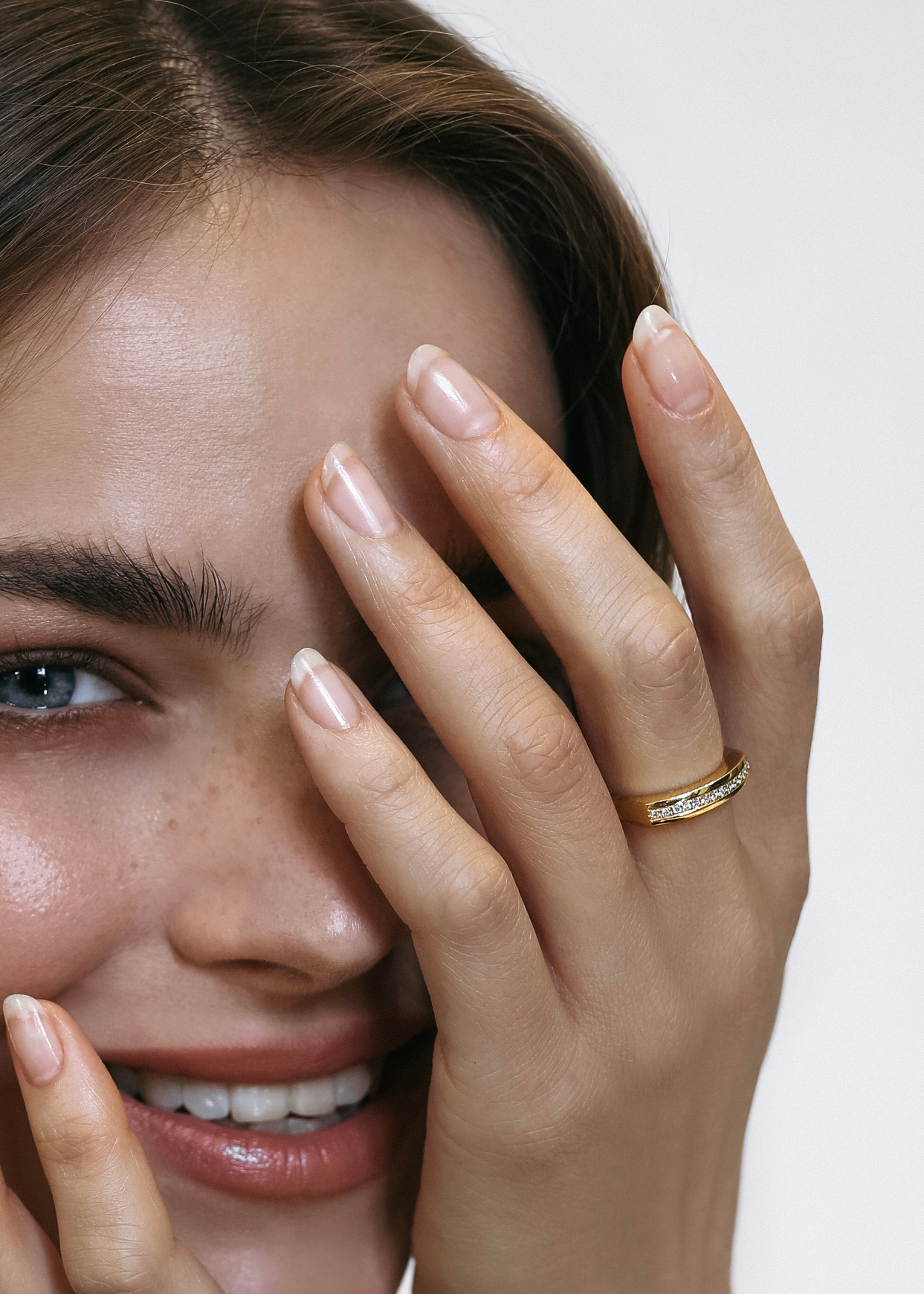 Close-up of a smiling model wearing the L’Arc ring by Presiada. Crafted in 18K gold, the bold arc design is enhanced with pavé-set diamonds (approximately 0.10 ct), combining sophistication and modern elegance. Perfect for everyday wear, the ring is available with natural or lab-grown diamonds as part of the Sensation Collection.