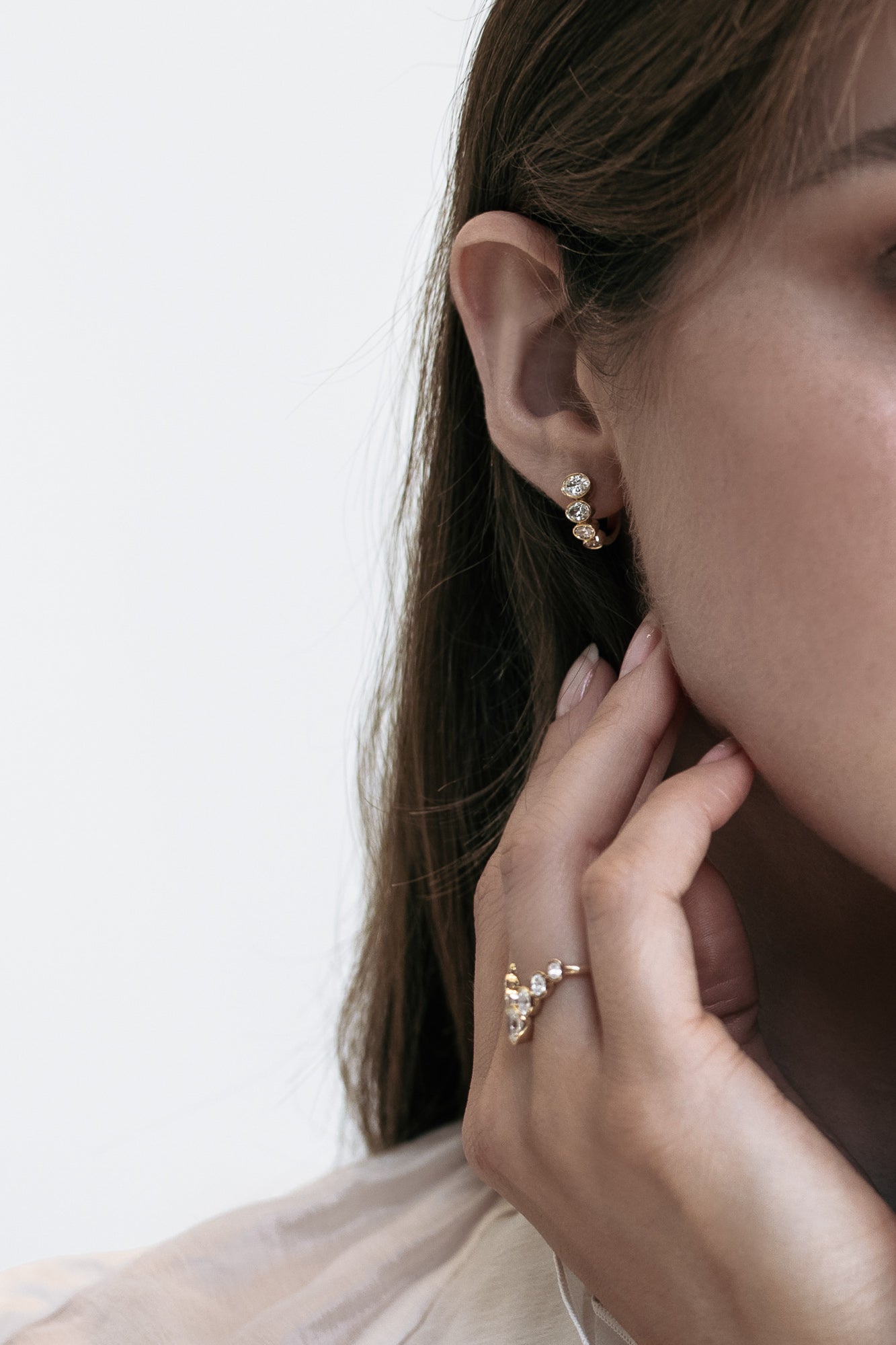 Side view of the Soleil earrings by Presiada, showcasing their luxurious design in 18K gold. Adorned with approximately 1 carat of oval lab-grown diamonds in VS clarity, these earrings add a touch of sophistication and brilliance to any look. Available in natural diamonds and customizable in yellow or white gold for a personalized touch.