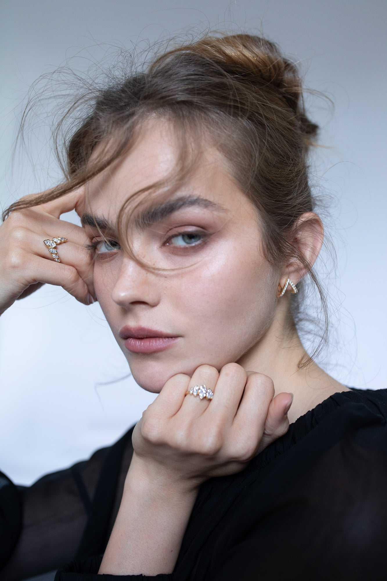 Elegant image of a model wearing Presiada's VIVID 18K gold earrings from the Sensation Collection, paired with two stunning engagement rings, J'ador V Flam and La Divine. These exquisite pieces, crafted with natural diamonds, highlight timeless luxury and modern sophistication, perfect for engagements and special occasions.