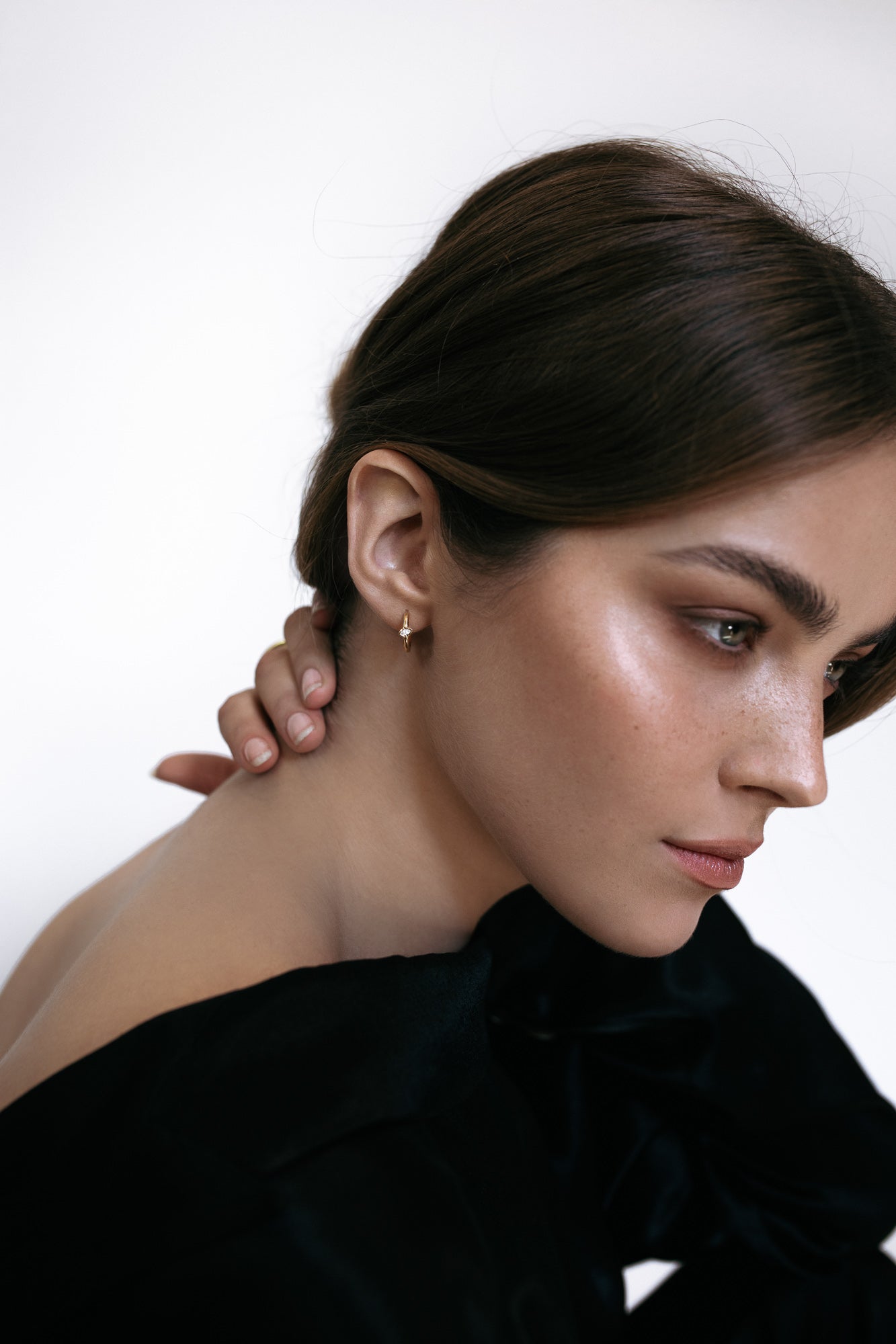 Side profile of a model wearing the Élany Hoops in 18k yellow gold, featuring delicate marquise diamonds totaling 0.1 ct. These earrings offer a modern twist on classic elegance, perfect for everyday sophistication.