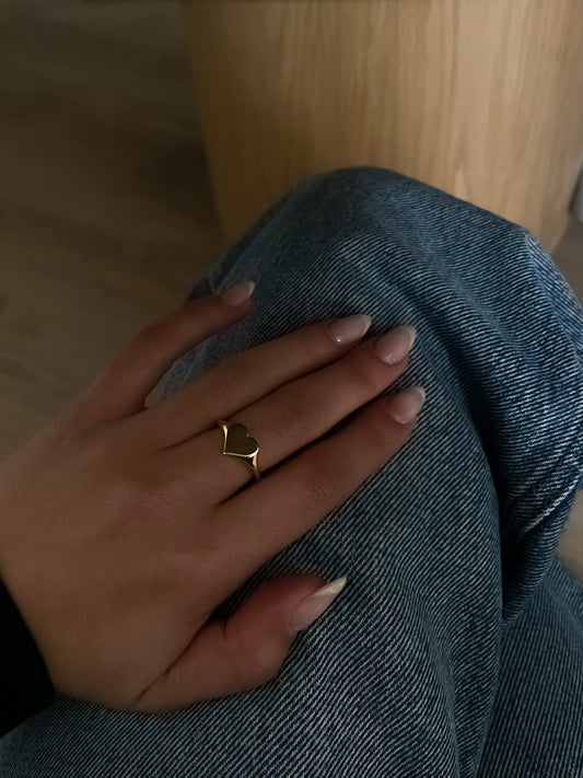 Model wearing the Fine Heart Signet Ring by Presiada, crafted in solid 14K or 18K gold. A bold yet refined heart-shaped ring that radiates elegance and love, designed to make a statement.